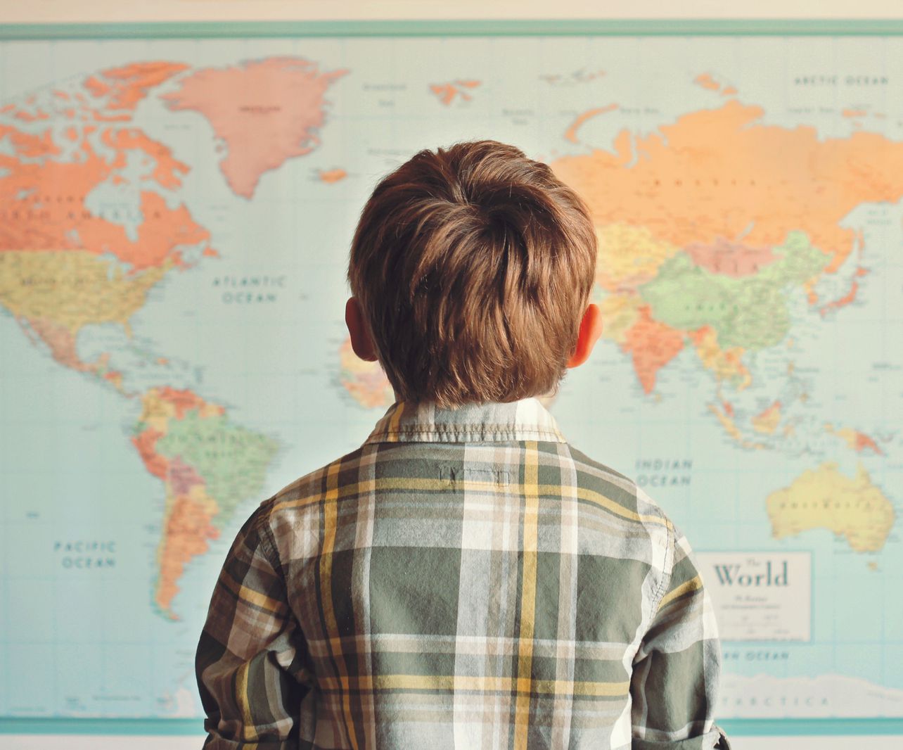 Young boy looking up at a map 